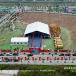 Outdoor event tent with PVC roof and corporate ceremony setup at industrial park construction site