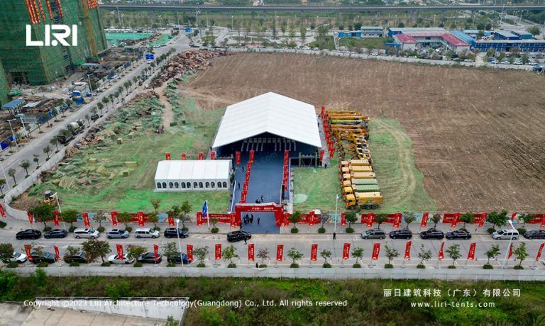 Outdoor event tent with PVC roof and corporate ceremony setup at industrial park construction site