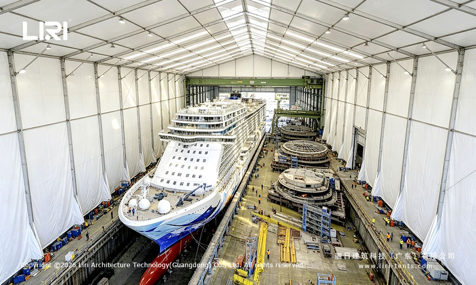Cruise ship inside a white clear-span tent at a shipyard