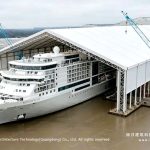 Cruise ship beside a clear-span tent structure at the waterfront