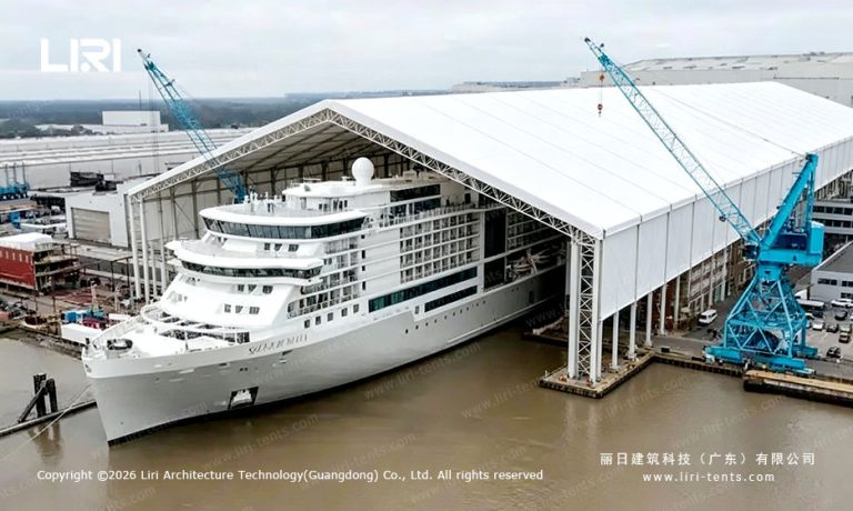 Cruise ship beside a clear-span tent structure at the waterfront
