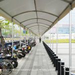 Canton Fair exhibition tent walkway cover beside parked scooters