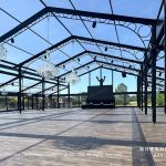 clear glass event tent interior with black frame and crystal chandeliers