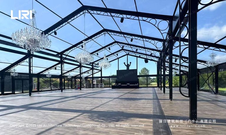 clear glass event tent interior with black frame and crystal chandeliers
