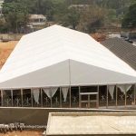 Interior of event tent showing layered curtains and air conditioning unit