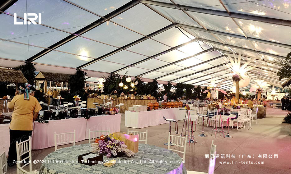 Food service area with tropical decor inside transparent event tent