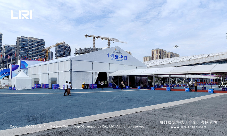 Aerial view of large A-frame security checkpoint tent at a Hainan trade show with international flags