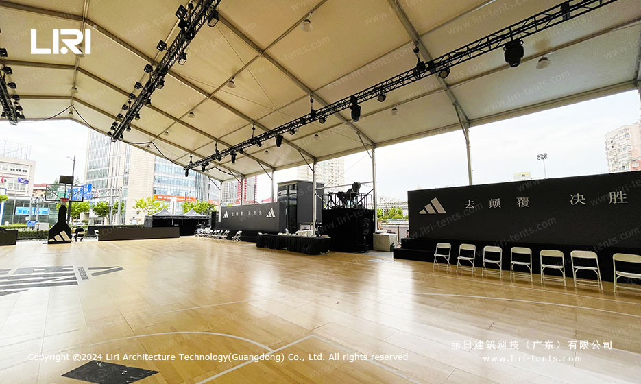 Indoor sports court tent with wood flooring and basketball markings