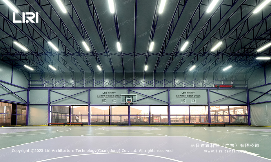 Basketball hoop under arched purple aluminum truss with glass wall system and netting