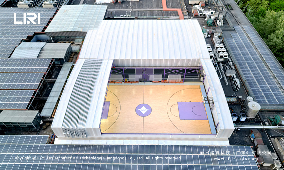 Aerial close-up showing electric retractable roof half-open over twin basketball courts