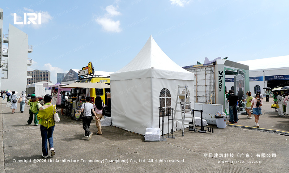 Pagoda entrance tent with arched window at a race track, with a clear span sponsor lounge tent visible in the background