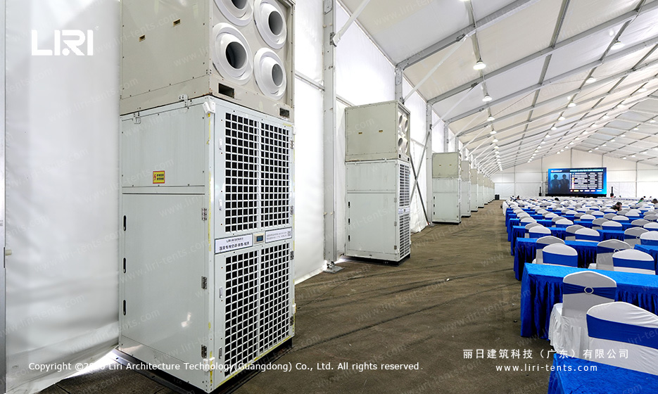 Roof-mounted industrial air conditioning units lined up along the side of a clear span event tent used as a race track spectator lounge