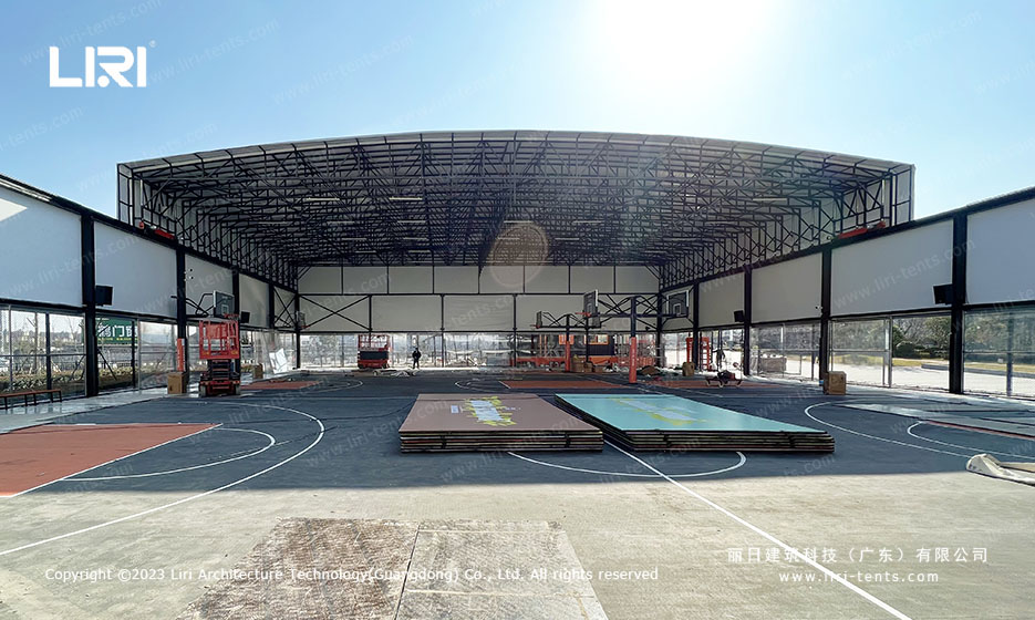 Retractable sports hall covering basketball court apron and side bleachers