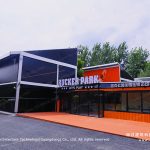 Rucker Park NO.102 badminton hall tent with glass wall and black facade in a city commercial district