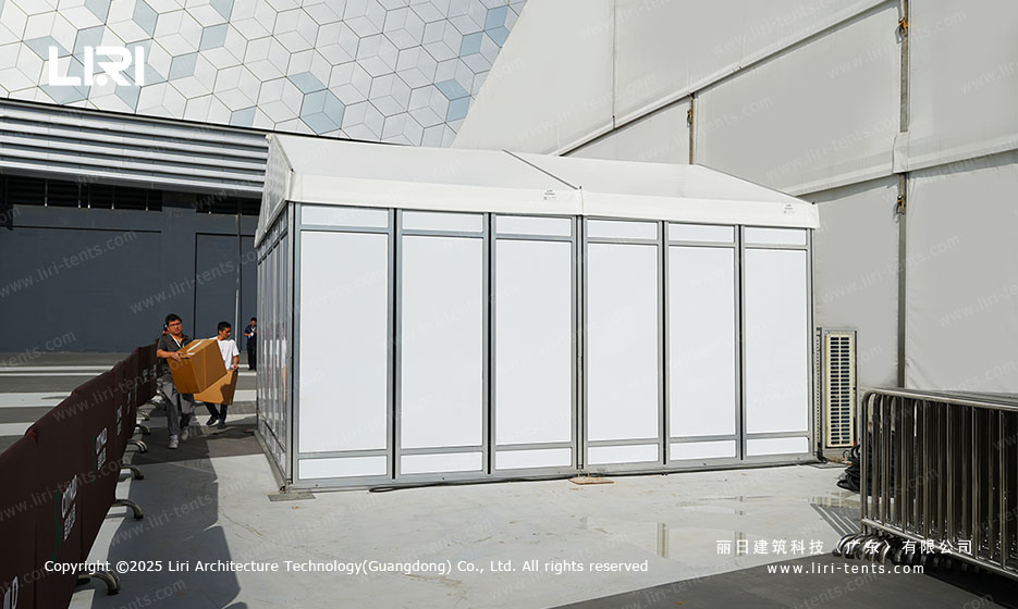 Modular hardwall container unit attached to the side of a large clear span event tent for a ceremony