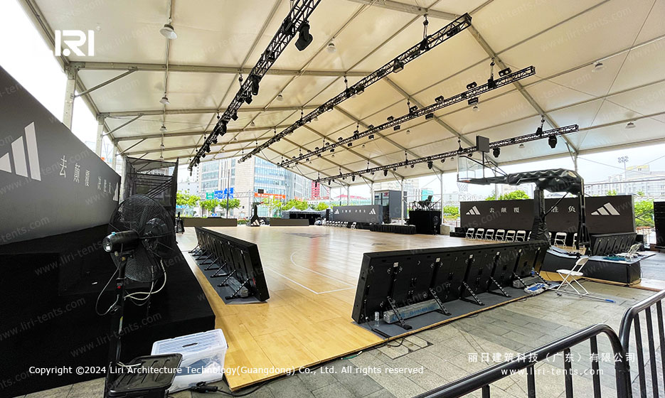 Sports event tent stage setup with seating and branding walls