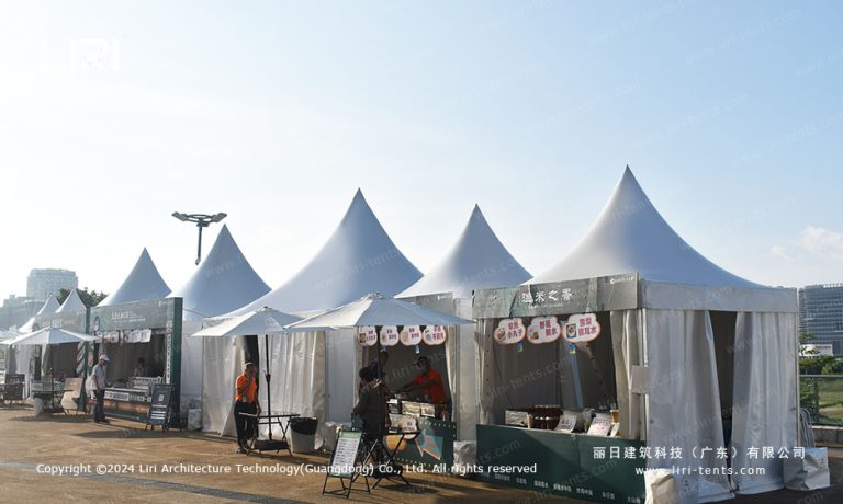 White pagoda tents forming food court row at outdoor tennis festival