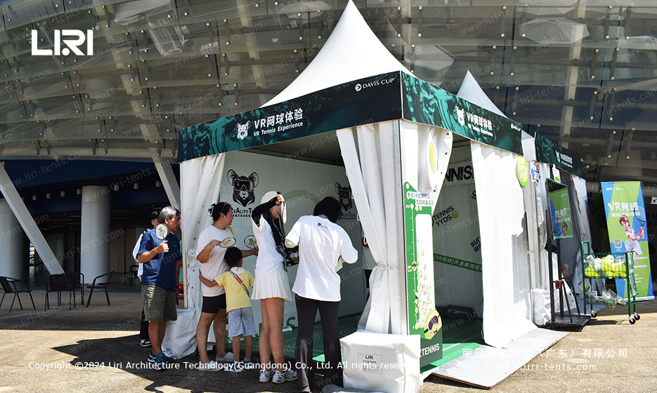 Tent village alongside outdoor tennis stadium at sports event